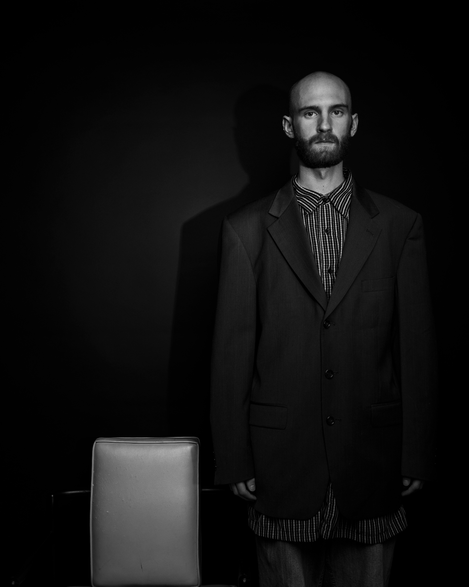 portrait of Keenan standing next to chair